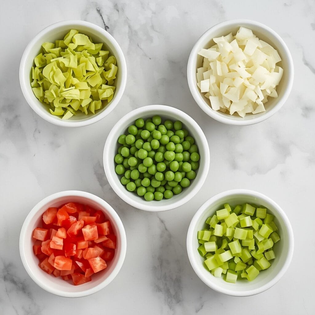 Flat lay of cabbage, onions, peppers, tomatoes, and celery in separate bowls