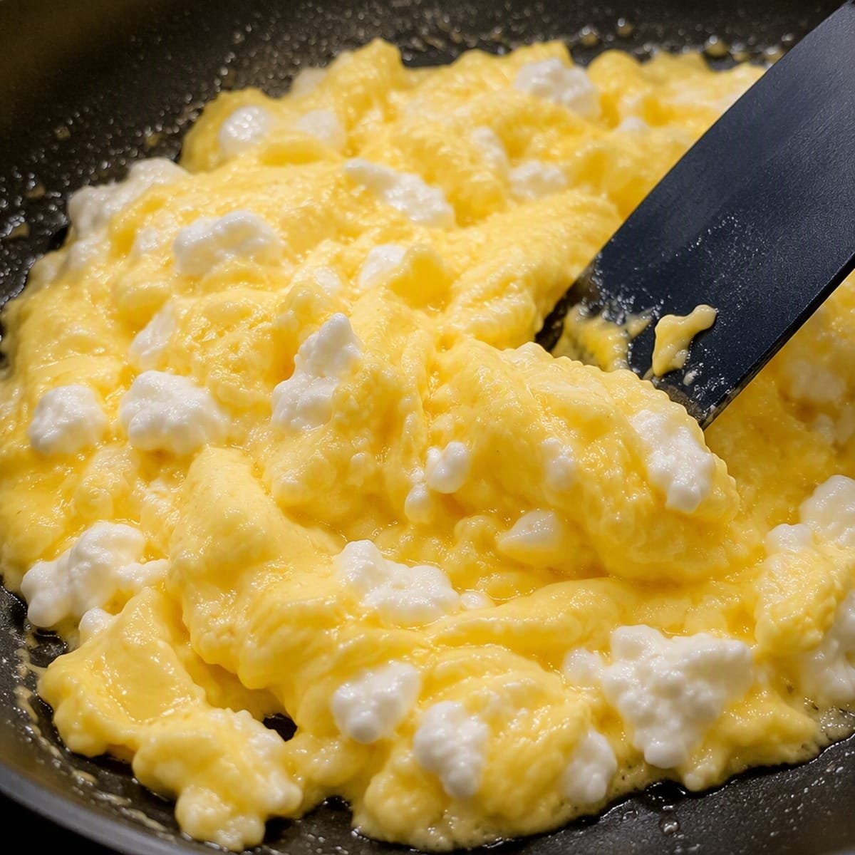 Cottage cheese eggs being gently folded in a nonstick skillet