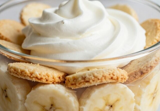 Banana pudding recipe layered with pudding, sliced bananas, and vanilla wafer cookies, topped with whipped topping