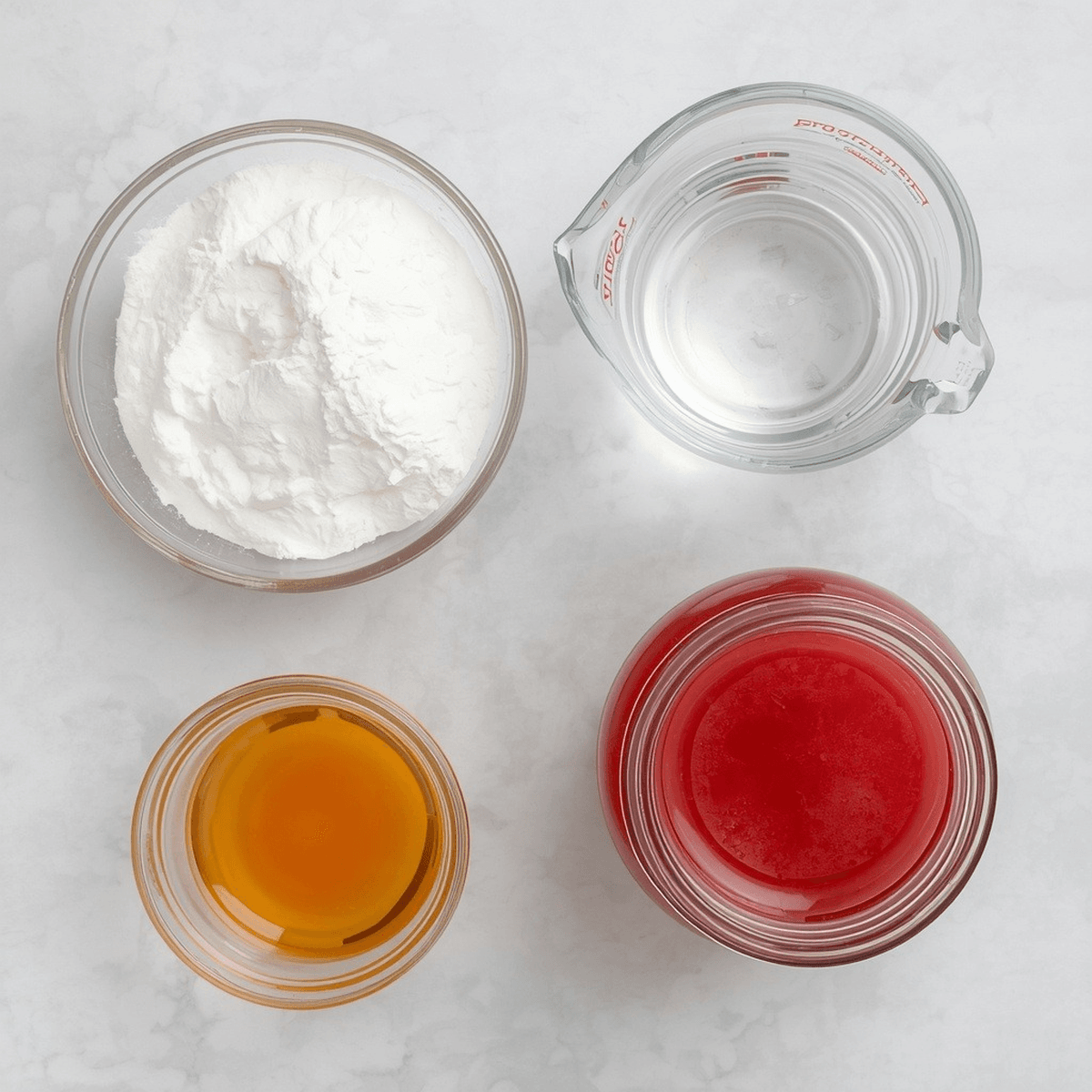 Overhead flat lay of gelatin recipe ingredients — sweetener, water, honey, and red juice — in separate glass bowls