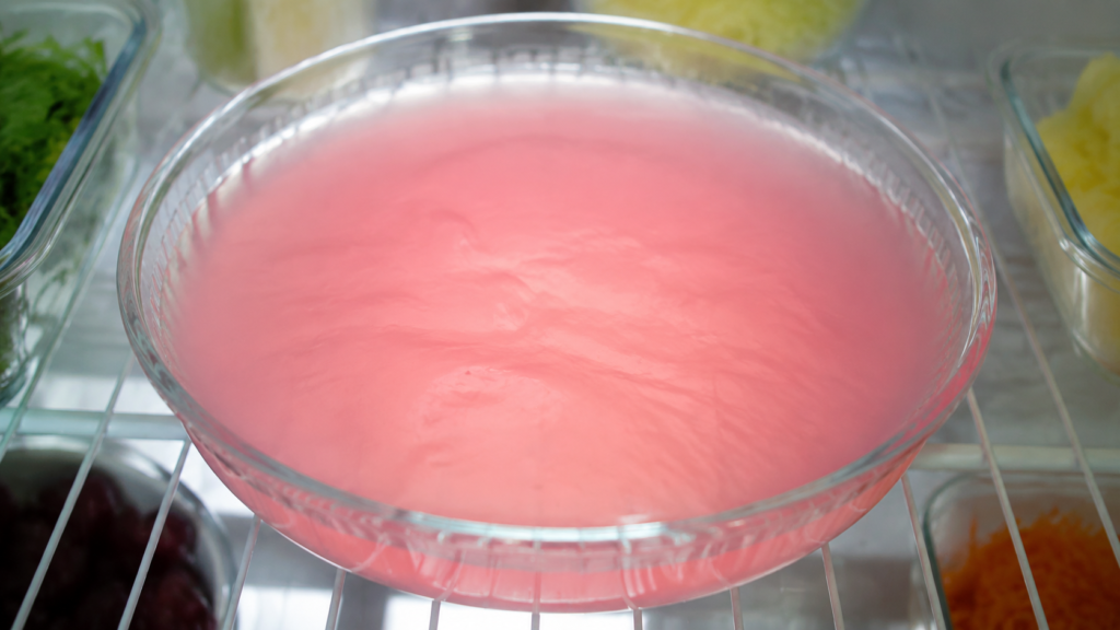 pink gelatin recipe setting in a dish in the refrigerator