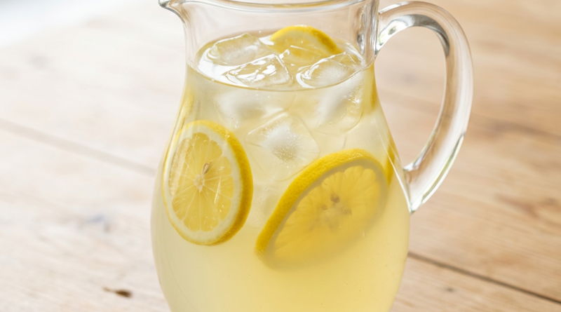 Lemonade recipe in a pitcher with lemon slices and ice
