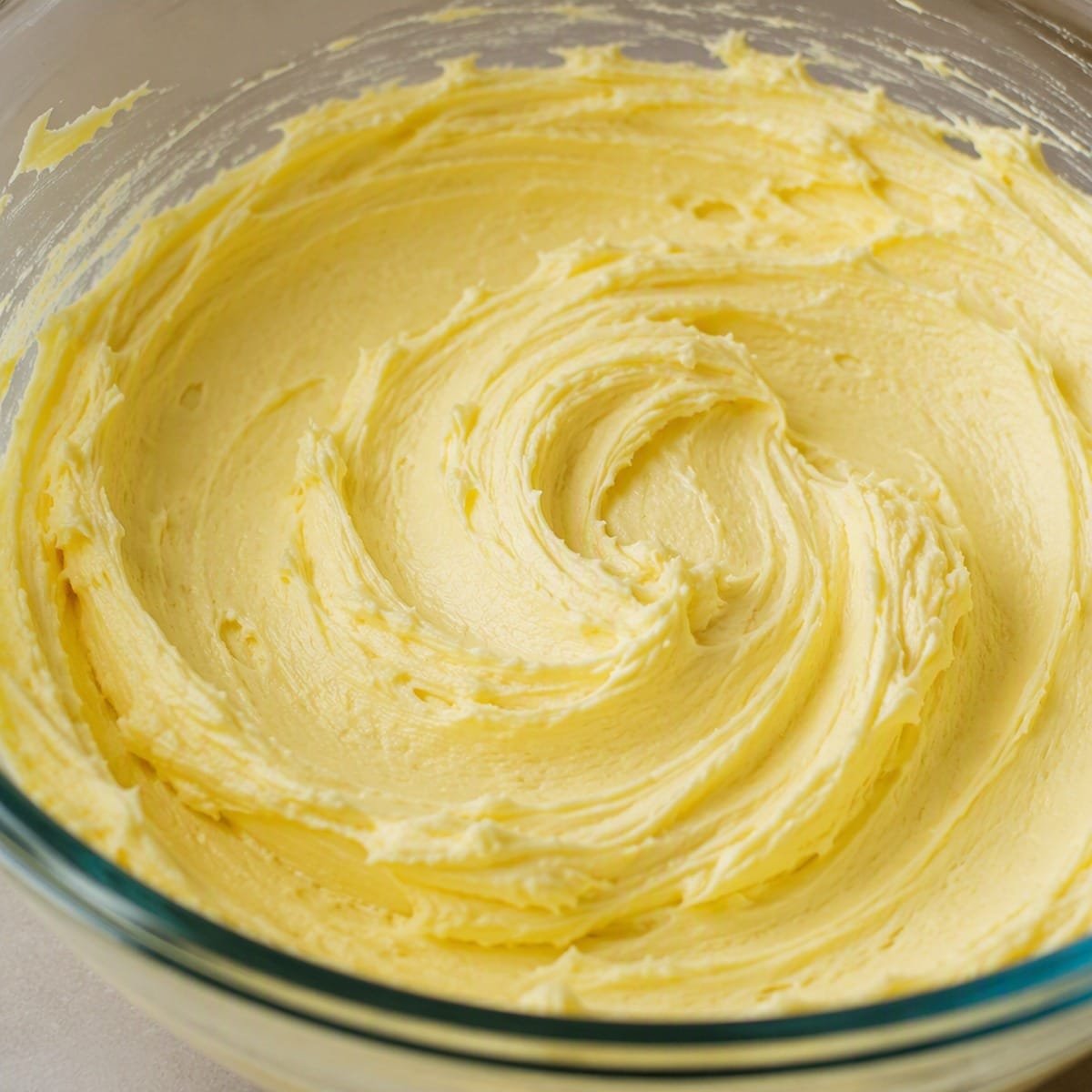 Creamed butter and sugar mixture in a glass mixing bowl