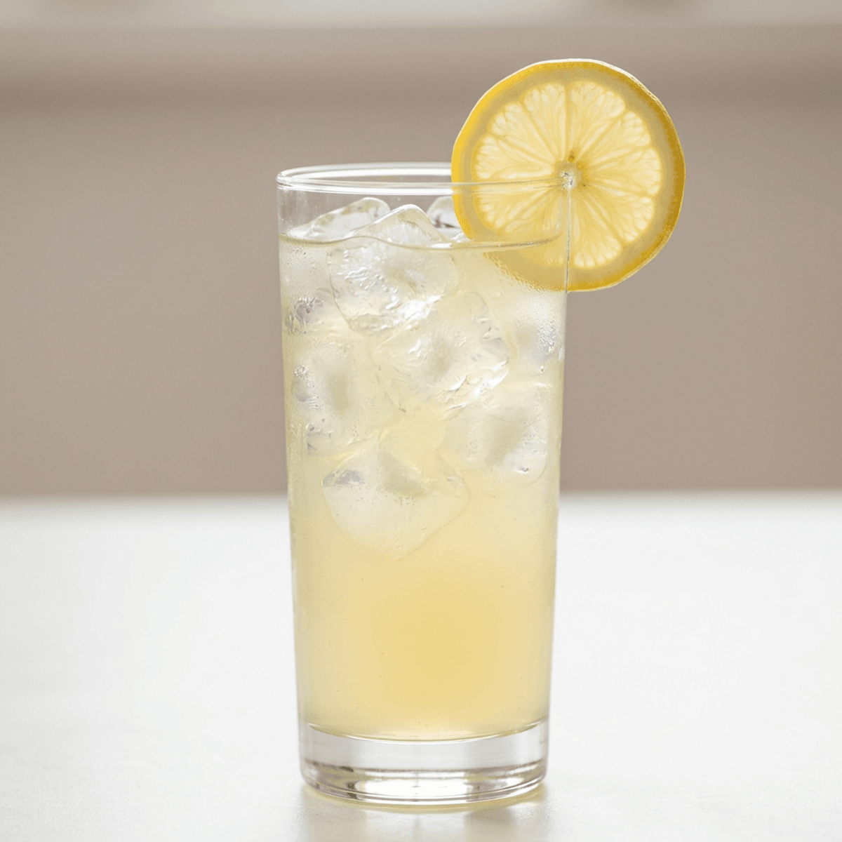 Square shot of a tall glass filled with  lemonade diet and ice cubes, garnished with a lemon slice on the rim