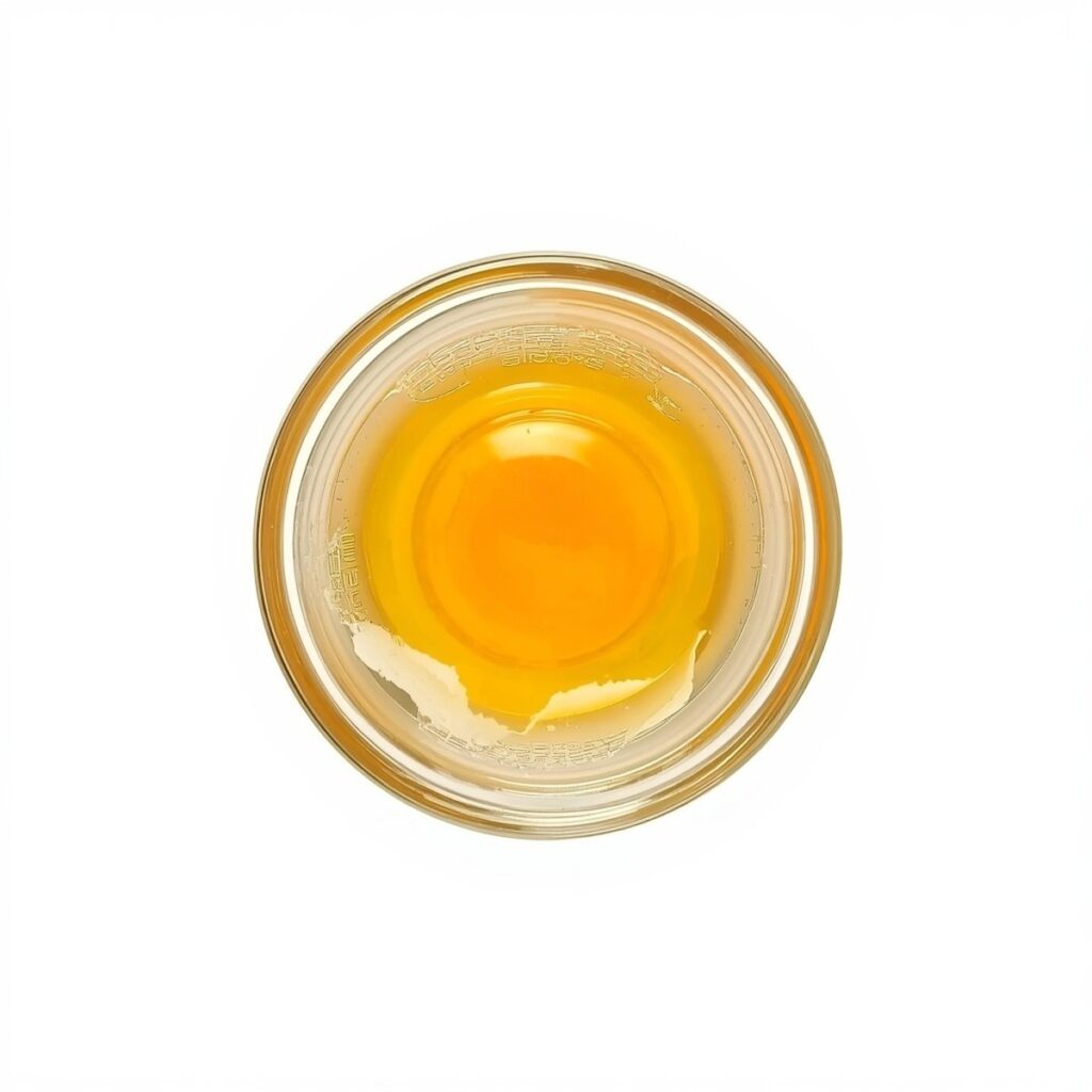 Overhead shot of a raw egg cracked into a small ramekin before poaching, no text, no labels, no background drinks or glasses of liquid
