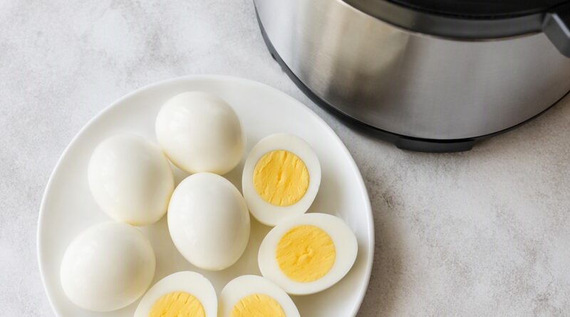 Instant Pot hard boiled eggs, whole and halved, showing smooth bright yellow yolks made using the 5-5-5 method
